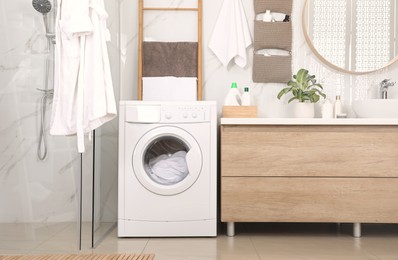 Stylish bathroom interior with modern washing machine