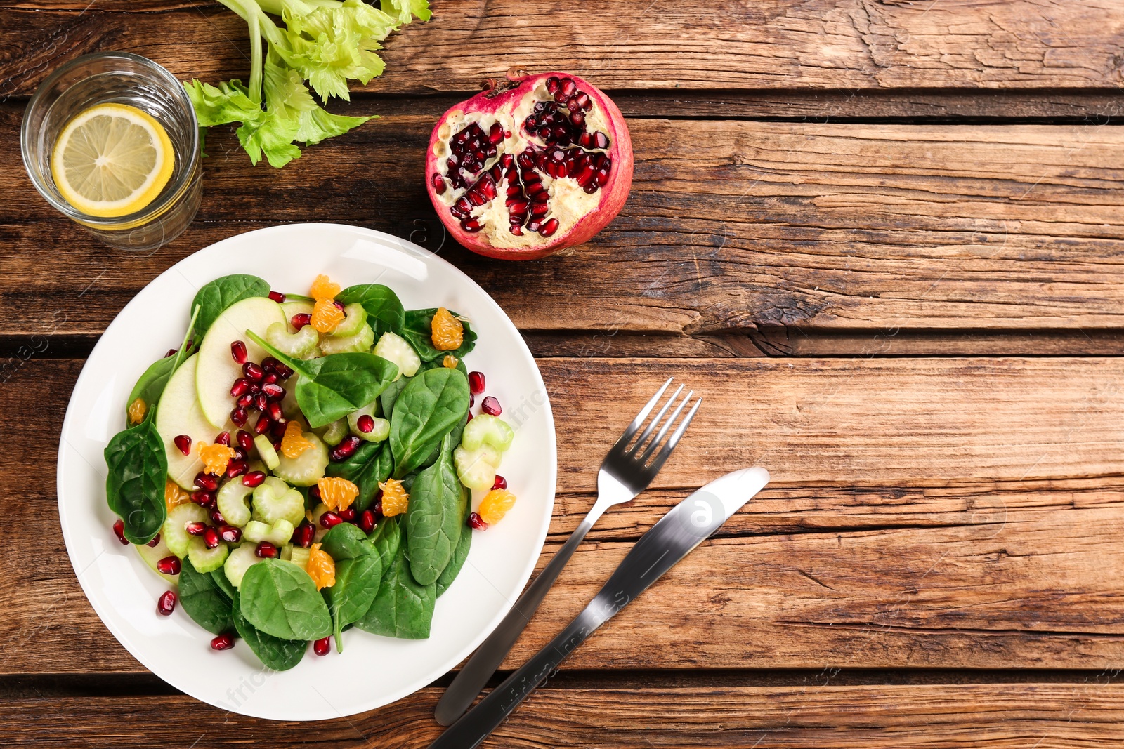 Photo of Delicious fresh celery salad served on wooden table, flat lay. Space for text