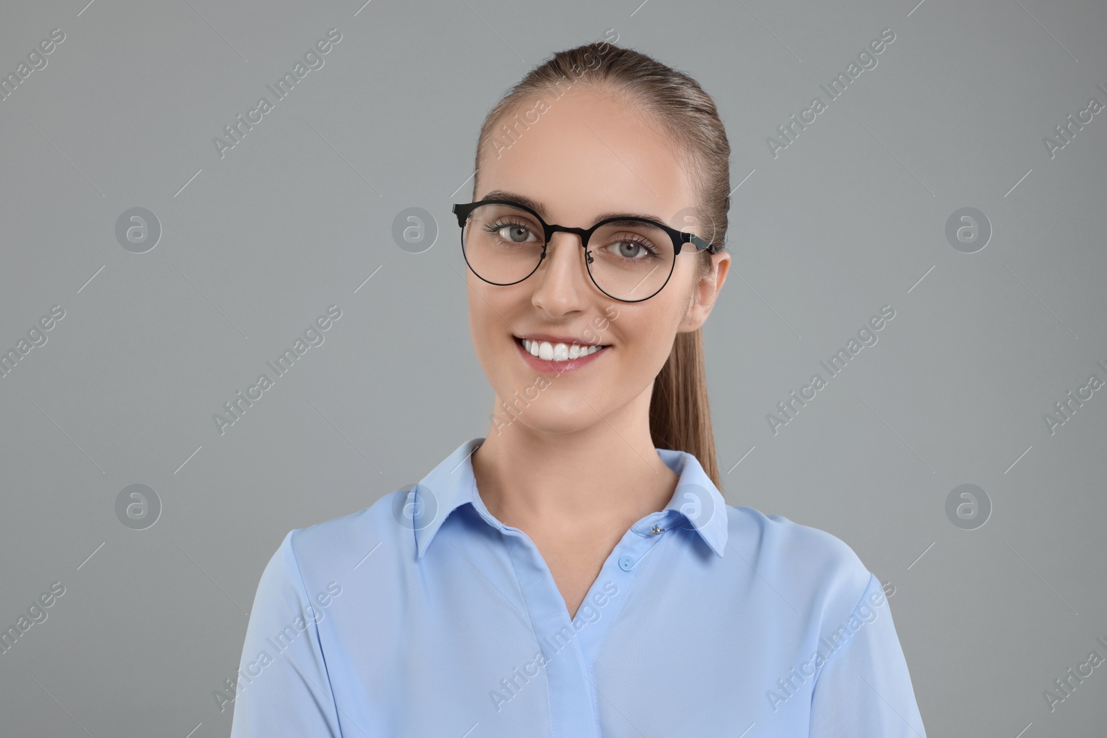 Photo of Portrait of happy young secretary on grey background