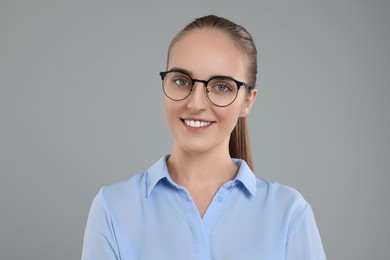 Photo of Portrait of happy young secretary on grey background