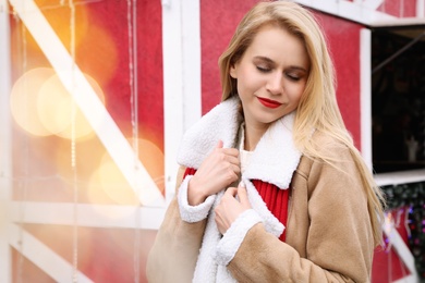 Young woman spending time at winter fair. Christmas celebration