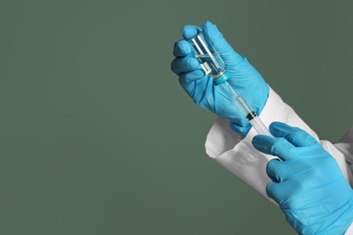 Photo of Doctor with syringe and medicine for vaccination on color background