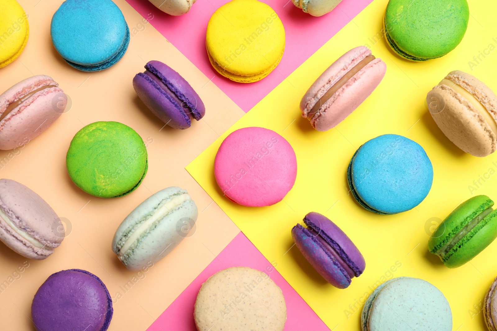Photo of Different delicious fresh macarons on color background, flat lay