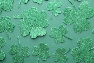 Photo of St. Patrick's day. Decorative clover leaves on green background, flat lay