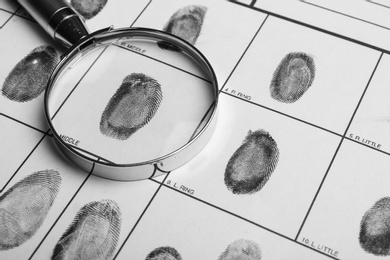 Magnifying glass and criminal fingerprint card, closeup