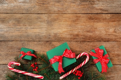 Photo of Flat lay composition with Christmas gift boxes on wooden background. Space for text