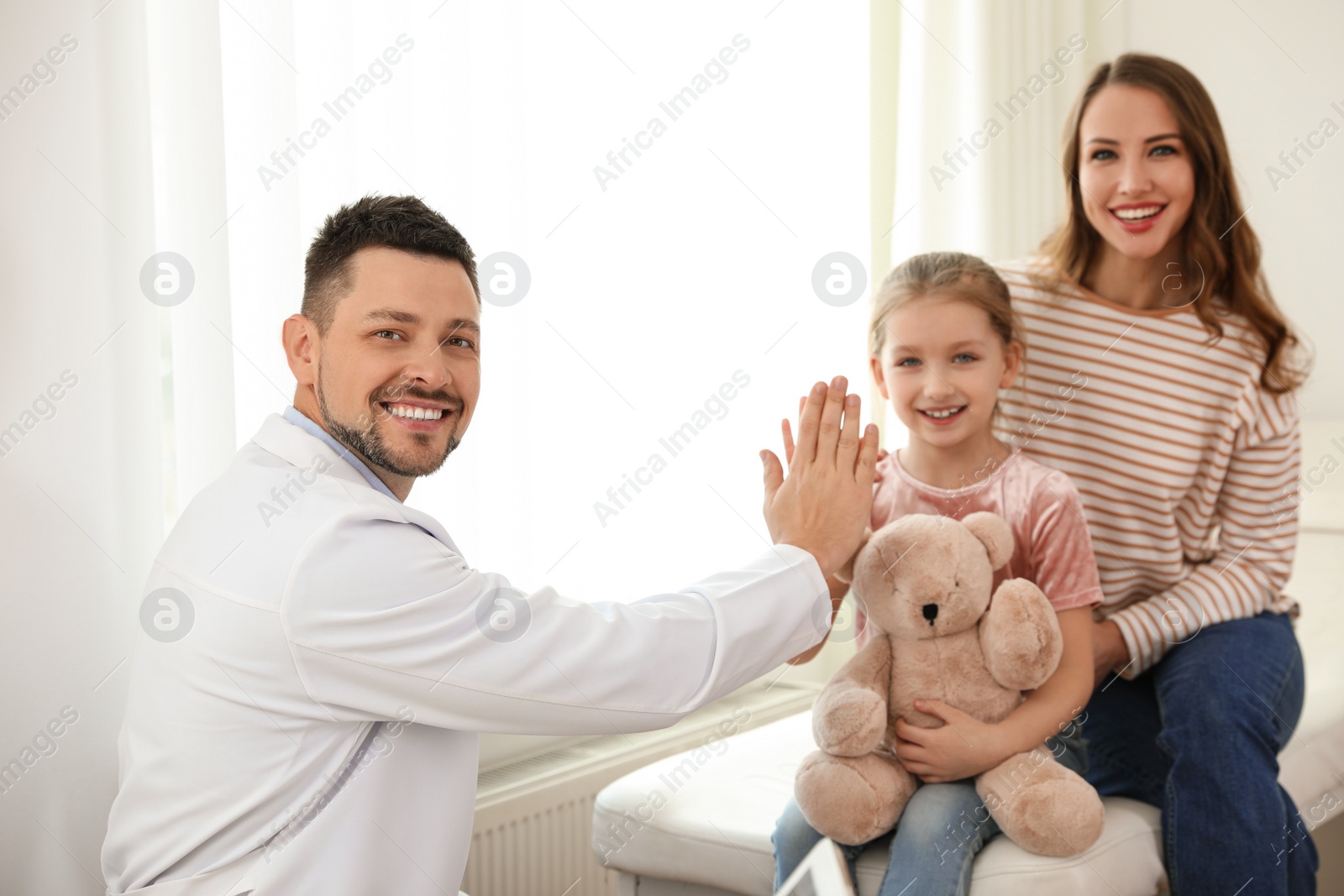 Photo of Mother and daughter visiting pediatrician. Doctor working with patient in hospital