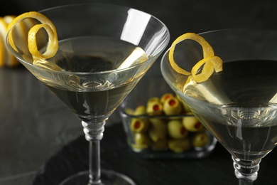 Photo of Glasses of Lemon Drop Martini cocktail with zest on grey table, closeup