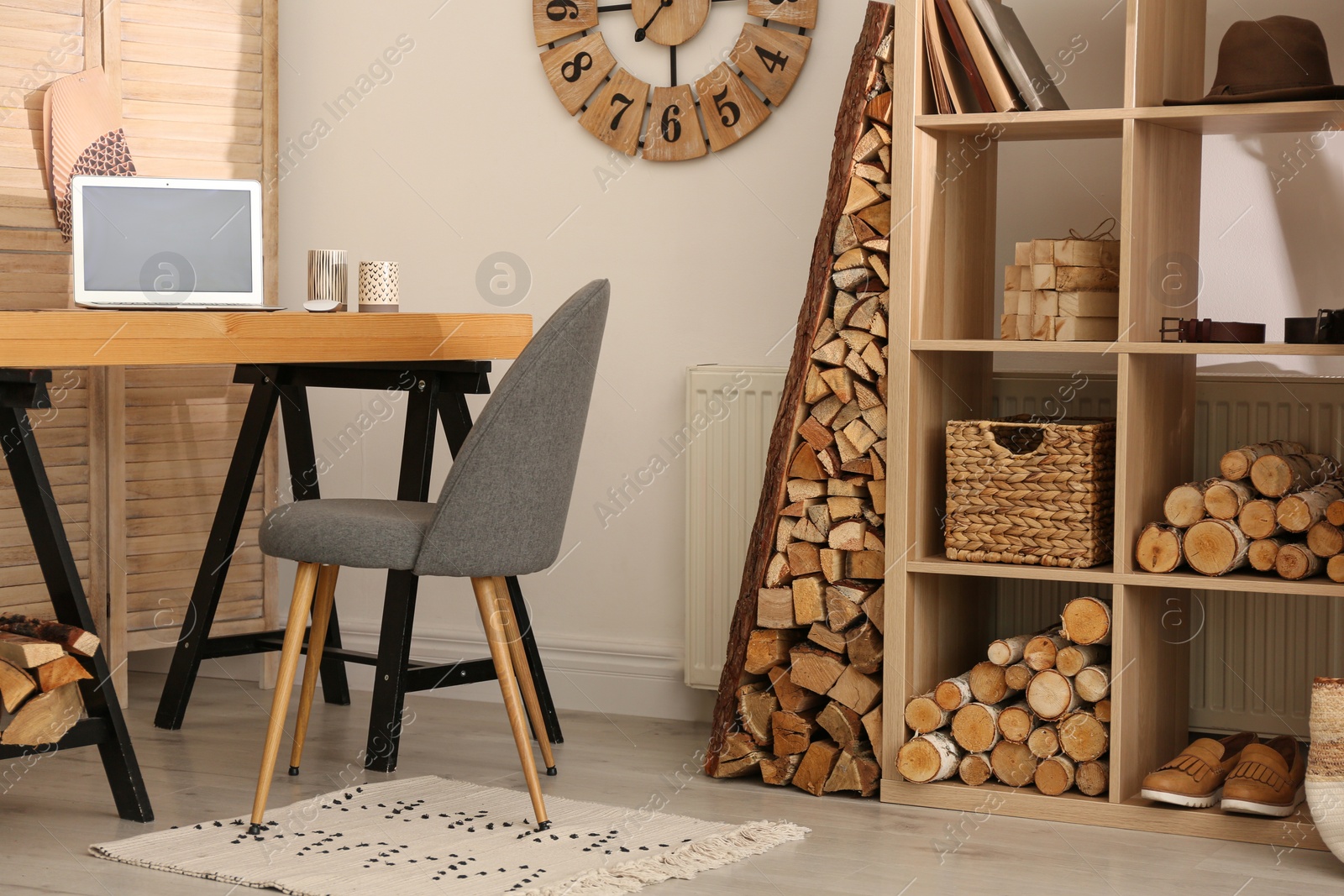 Photo of Stylish room interior with firewood as decorative element