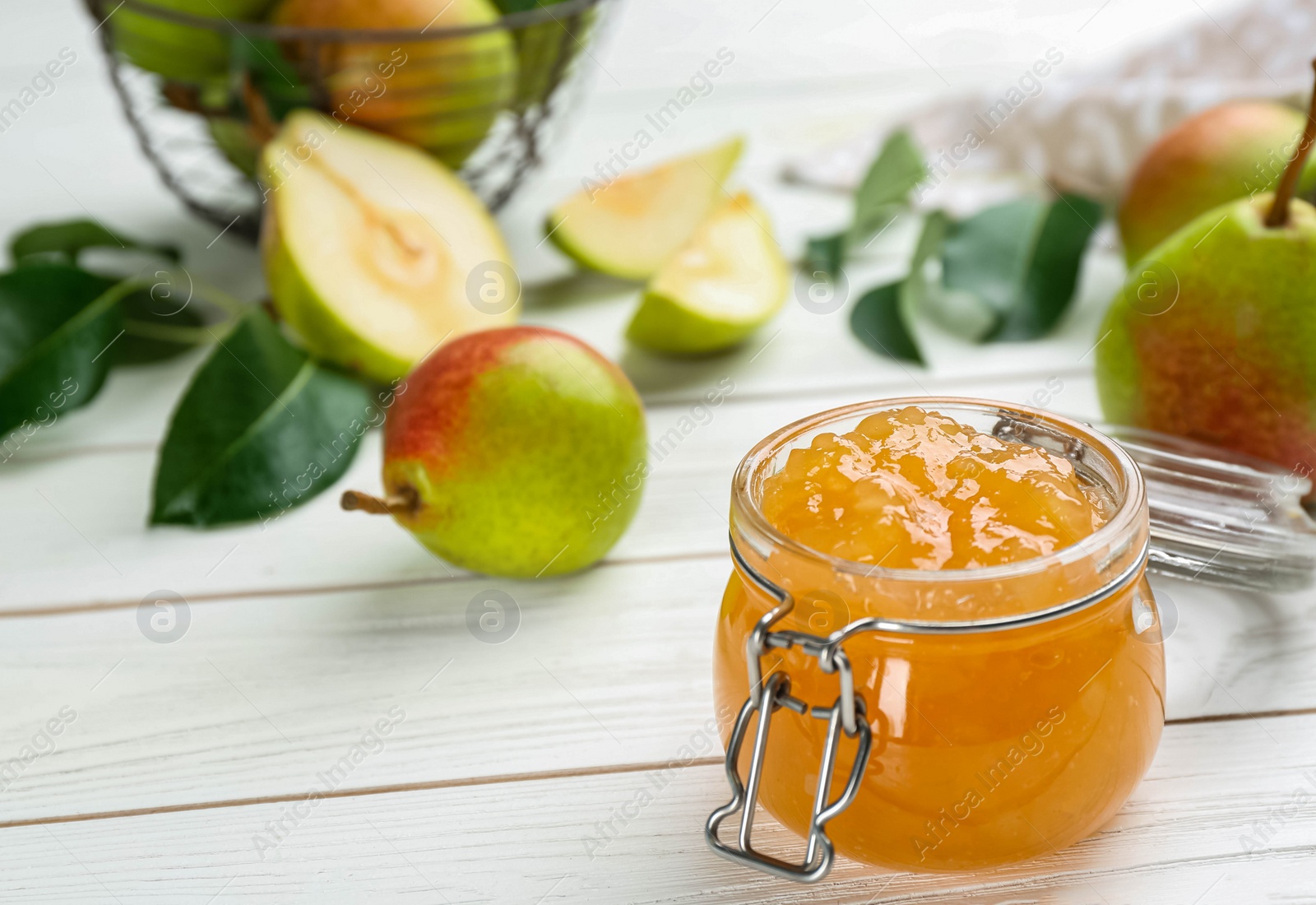 Photo of Delicious pear jam and fresh fruits on white wooden table. Space for text