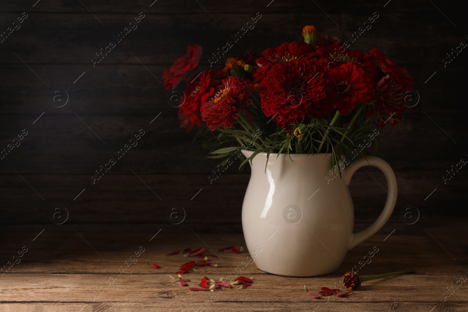 Photo of Bouquet of beautiful wild flowers on wooden table against black background. Space for text