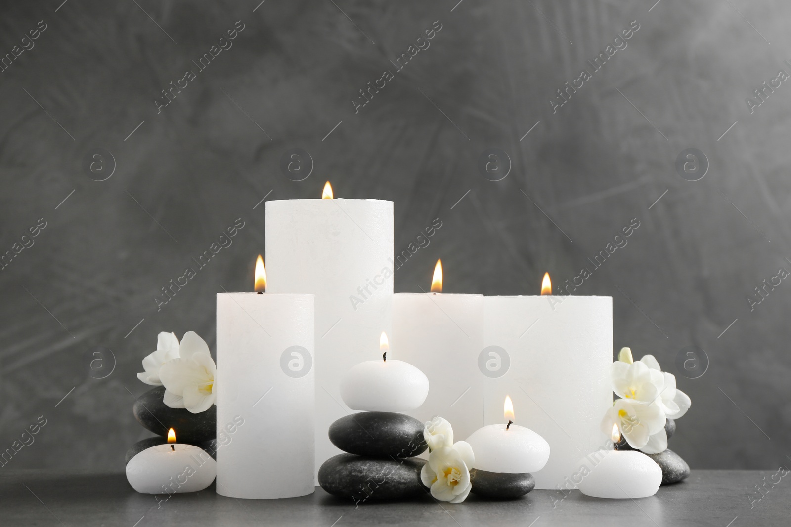 Photo of Beautiful composition with lit candles and flowers on table