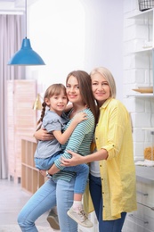 Photo of Beautiful mature woman with daughter and grandchild in kitchen