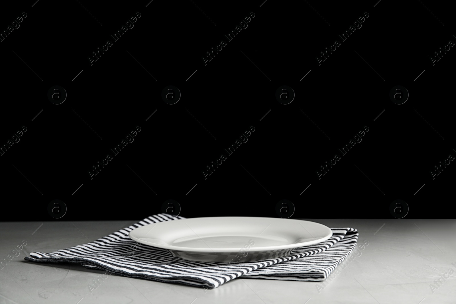 Photo of Empty ceramic plate and towel on light grey table