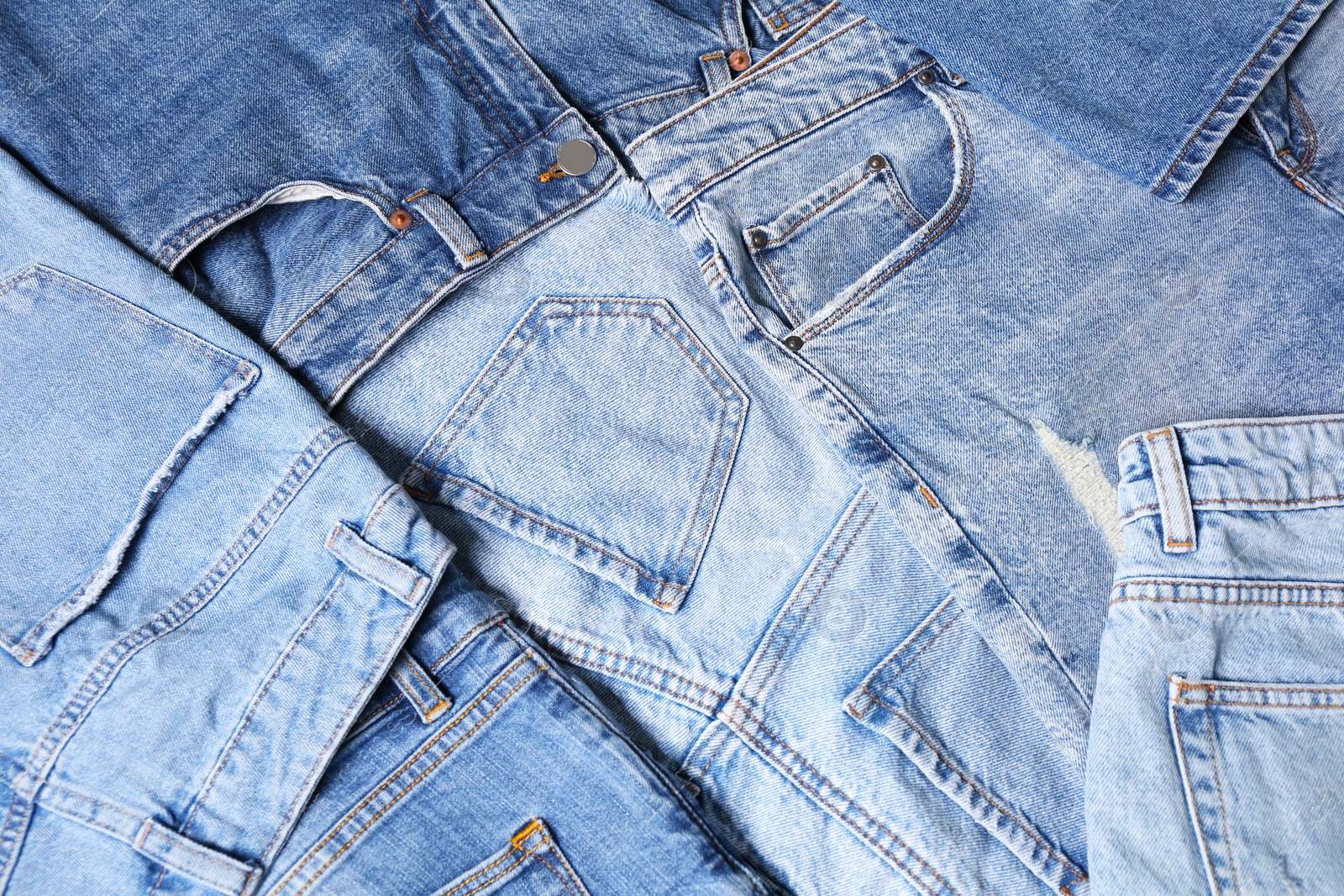 Photo of Variety of jeans with different pockets as background, closeup