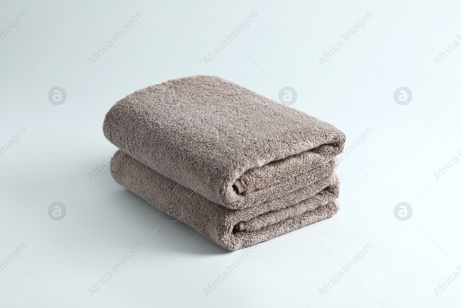 Photo of Stack of fresh fluffy towels on grey background