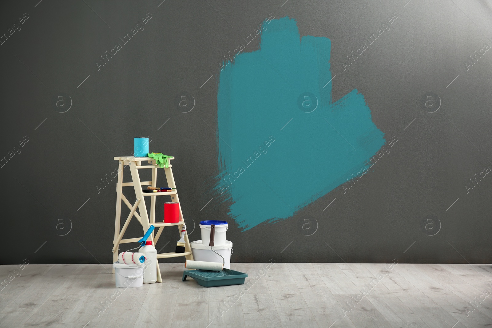 Image of Set with decorator's tools and paint on floor near grey wall