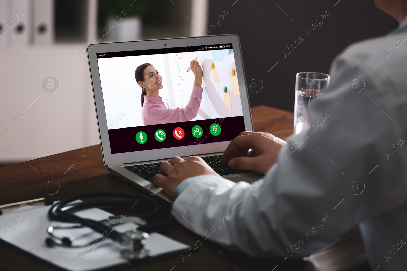 Image of Doctor having online video consultation with business trainer at table, closeup