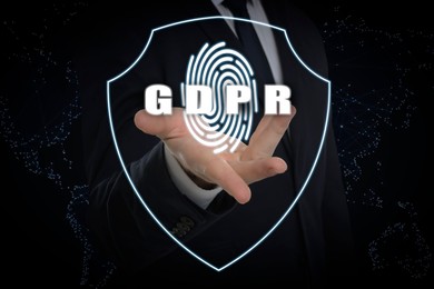 Image of General Data Protection Regulation. Man holding shield with fingerprint and GDPR abbreviation against black background with world map, closeup