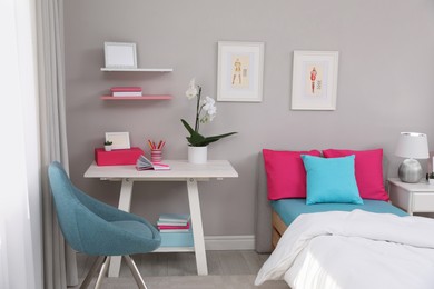 Photo of Modern teenager's room interior with comfortable bed and workplace