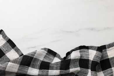 Black checkered tablecloth on white marble table, top view. Space for text