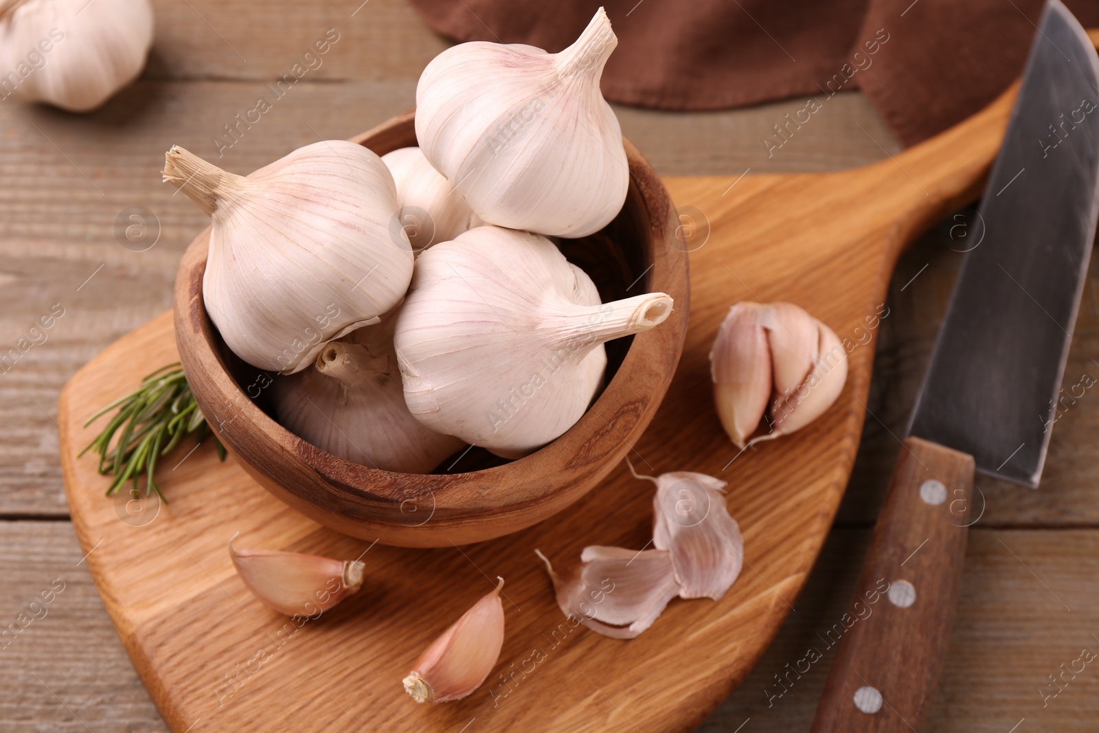 Photo of Fresh garlic and knife on wooden table, closeup. Above view