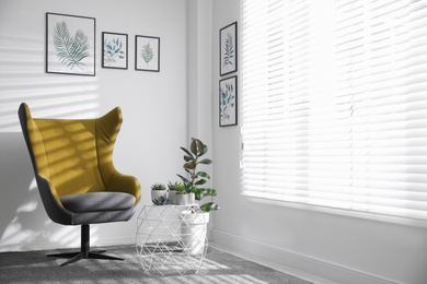 Photo of Comfortable armchair near white wall in light room