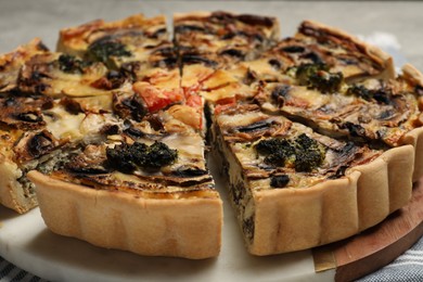 Photo of Delicious quiche with mushrooms on board, closeup