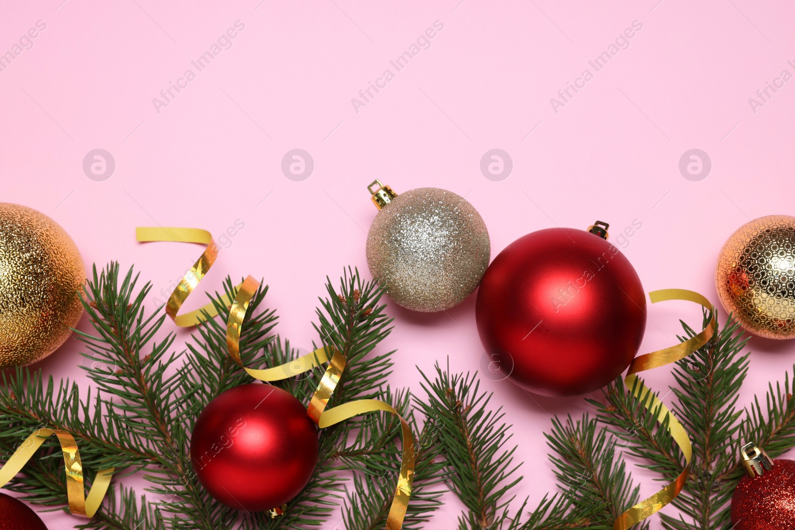 Photo of Shiny Christmas balls, streamers and fir tree branches on pink background, flat lay. Space for text