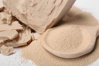 Photo of Compressed and granulated yeast on white background, closeup