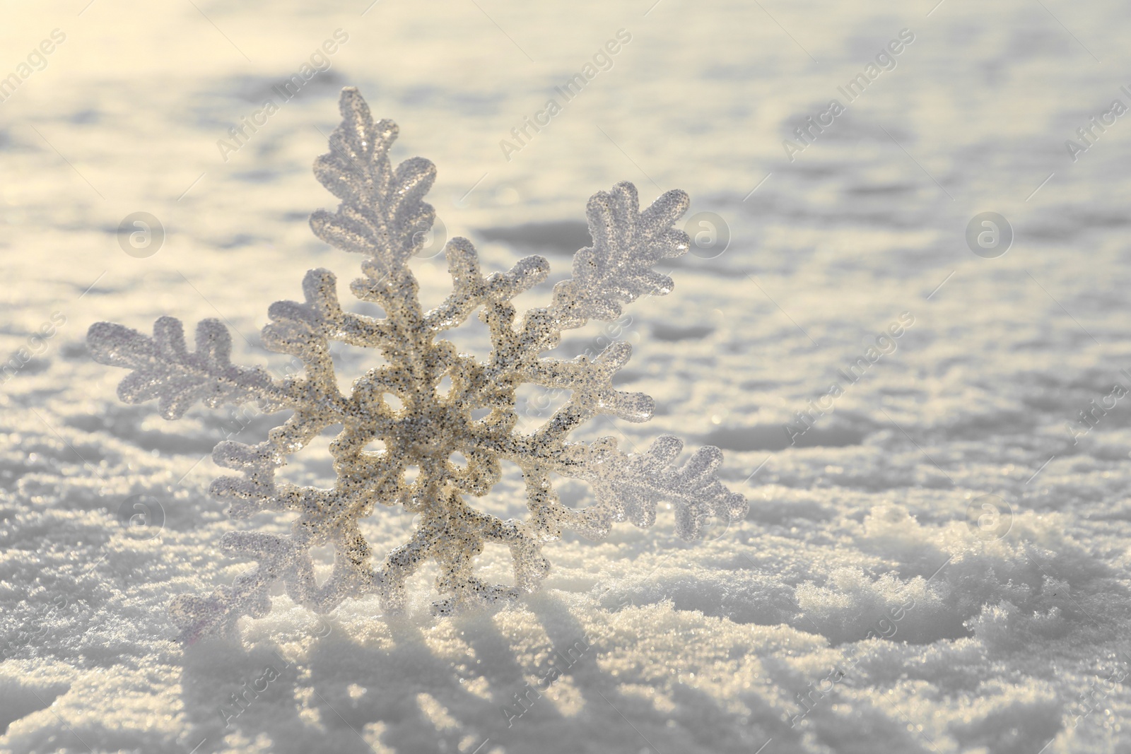 Photo of Beautiful decorative snowflake in white snow, outdoors. Space for text