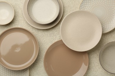 Photo of Beautiful ceramic plates and bowls on beige table, flat lay