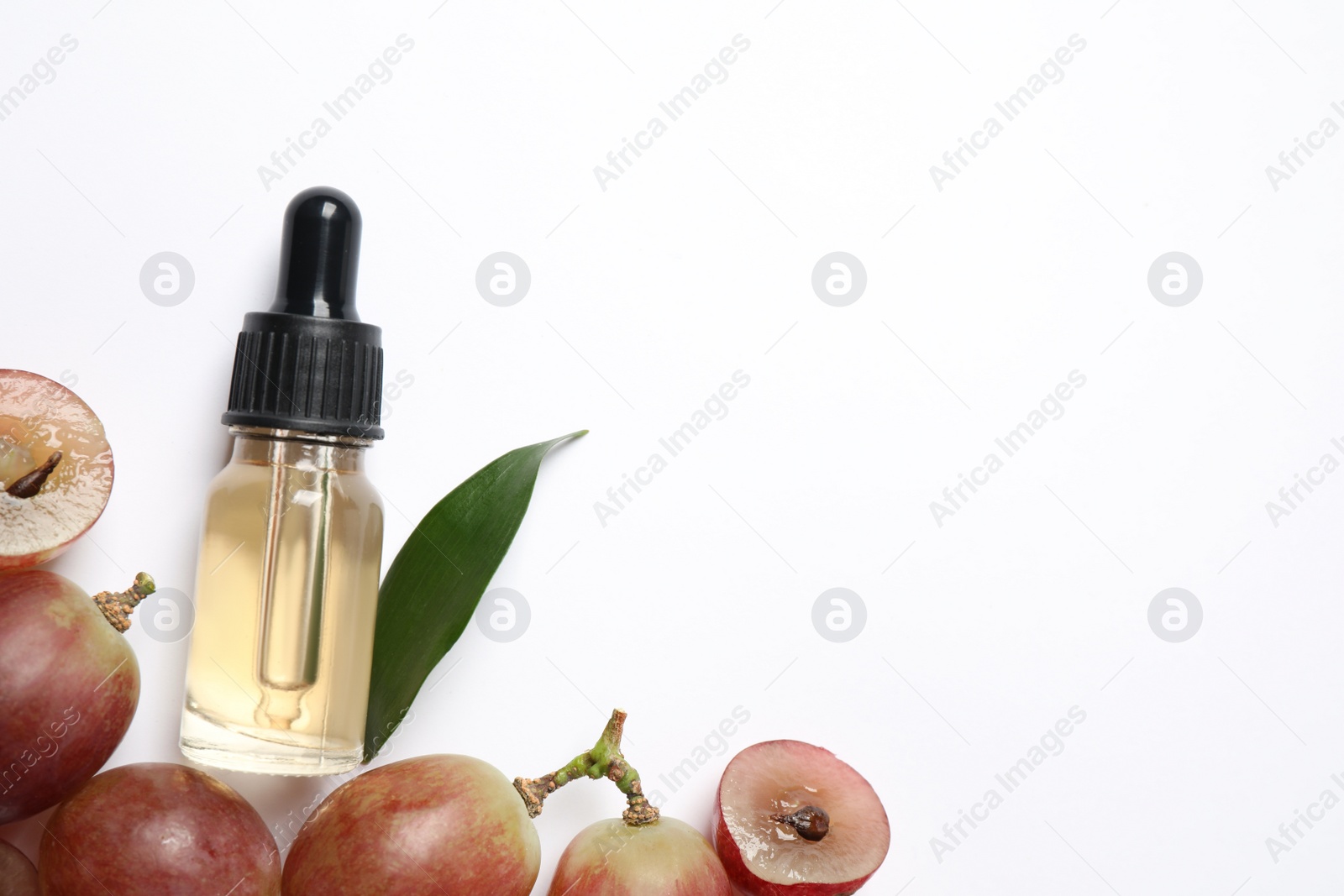 Photo of Composition with natural grape seed oil on white background, top view. Organic cosmetic