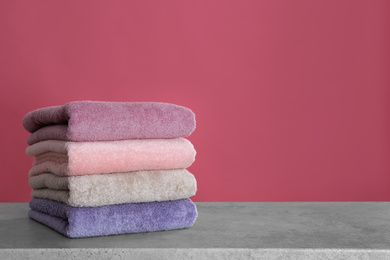 Stack of color towels on light grey stone table. Space for text