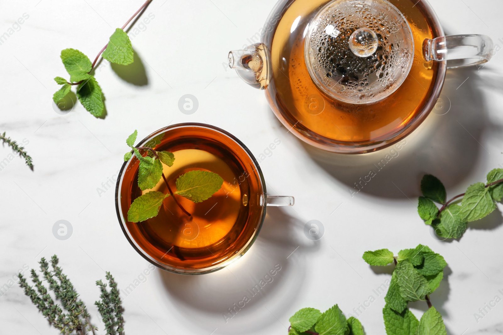 Photo of Aromatic herbal tea with mint and thyme on white table, flat lay