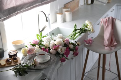 Beautiful peonies and breakfast on kitchen counter