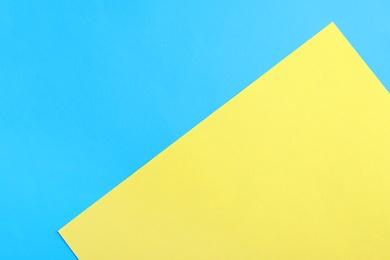 Photo of Blue and yellow paper sheets as colorful background, top view