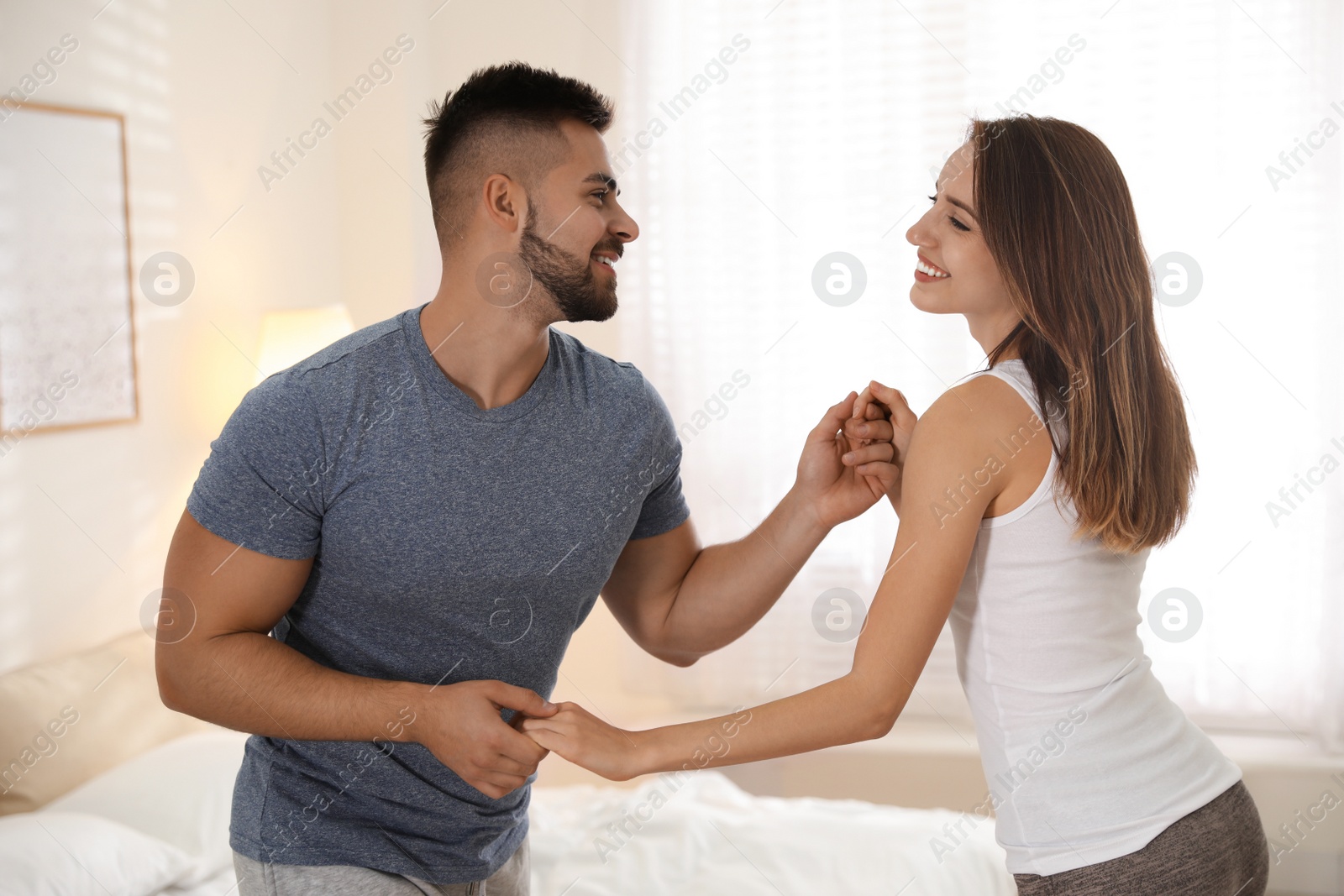 Photo of Lovely young couple dancing in bedroom at home