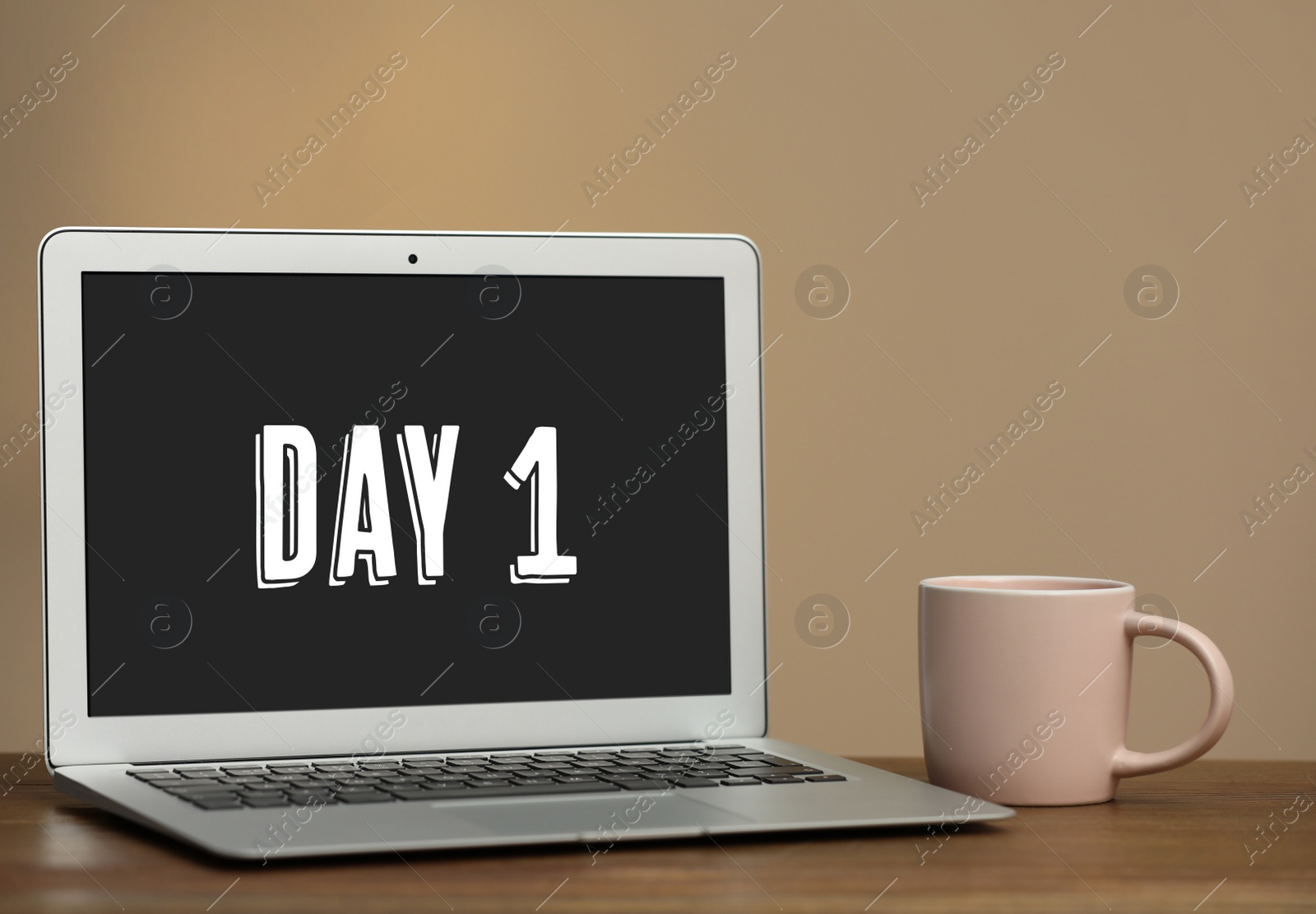 Image of Start new job. Laptop with text Day 1 on screen and cup in office