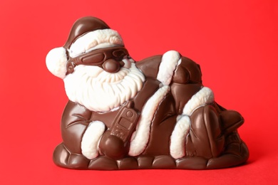 Sweet chocolate Santa Claus candy on red background