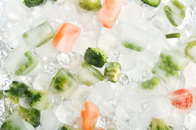 Photo of Frozen vegetables and ice cubes as background