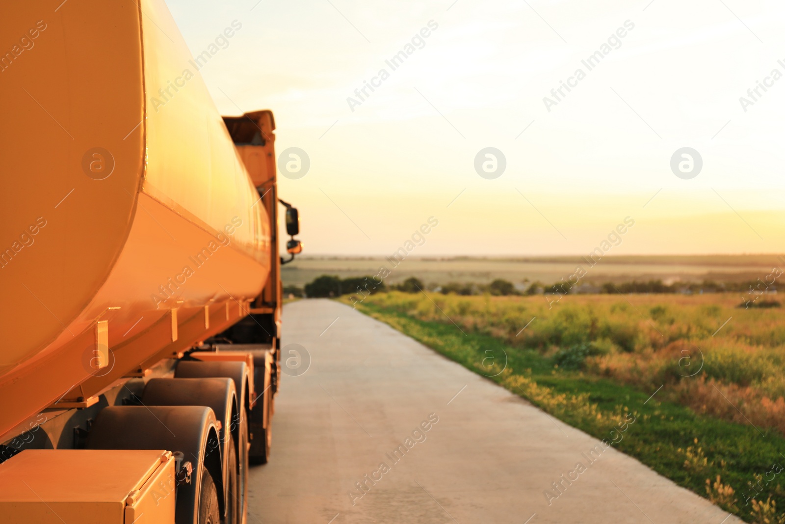 Photo of Modern yellow truck parked on country road