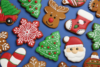 Photo of Different tasty Christmas cookies on blue background, flat lay