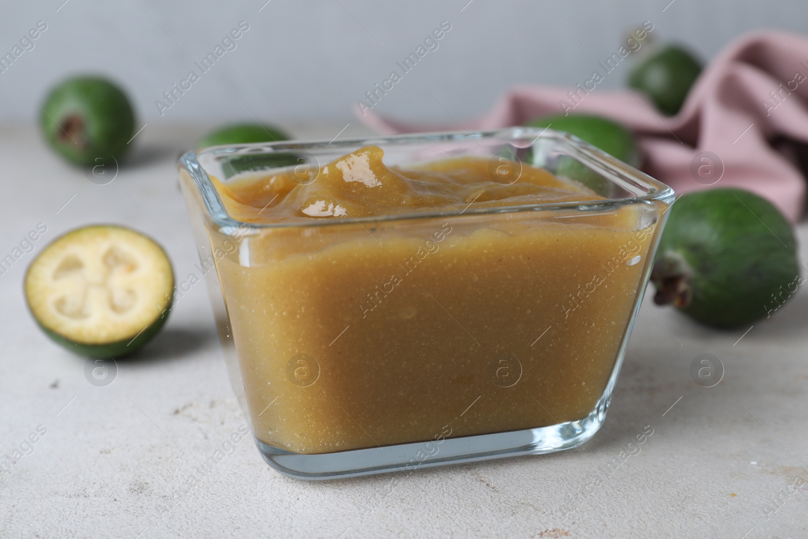 Photo of Feijoa jam on light grey table, closeup