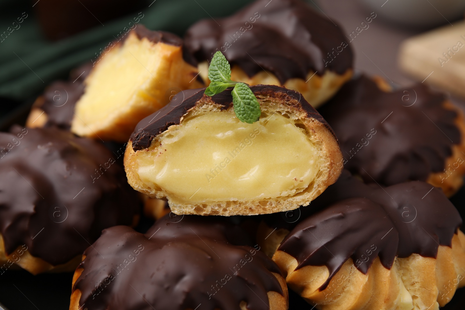 Photo of Delicious profiteroles with chocolate spread and cream, closeup