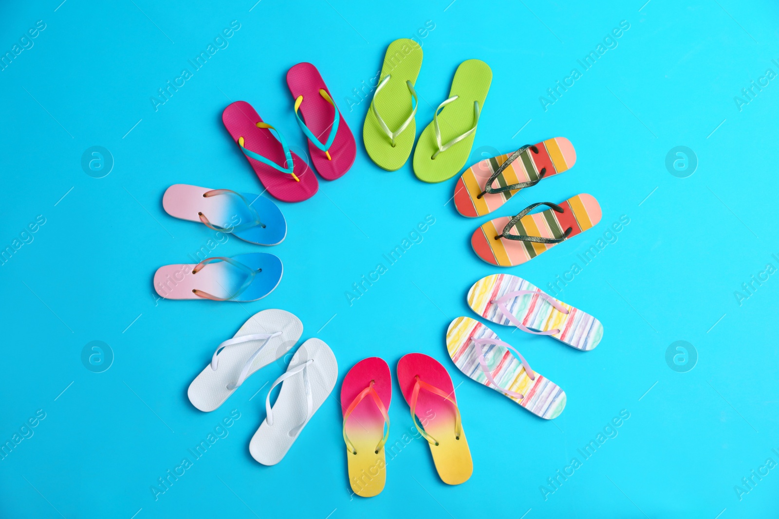 Photo of Flat lay composition with different flip flops on blue background, space for text. Summer beach accessories