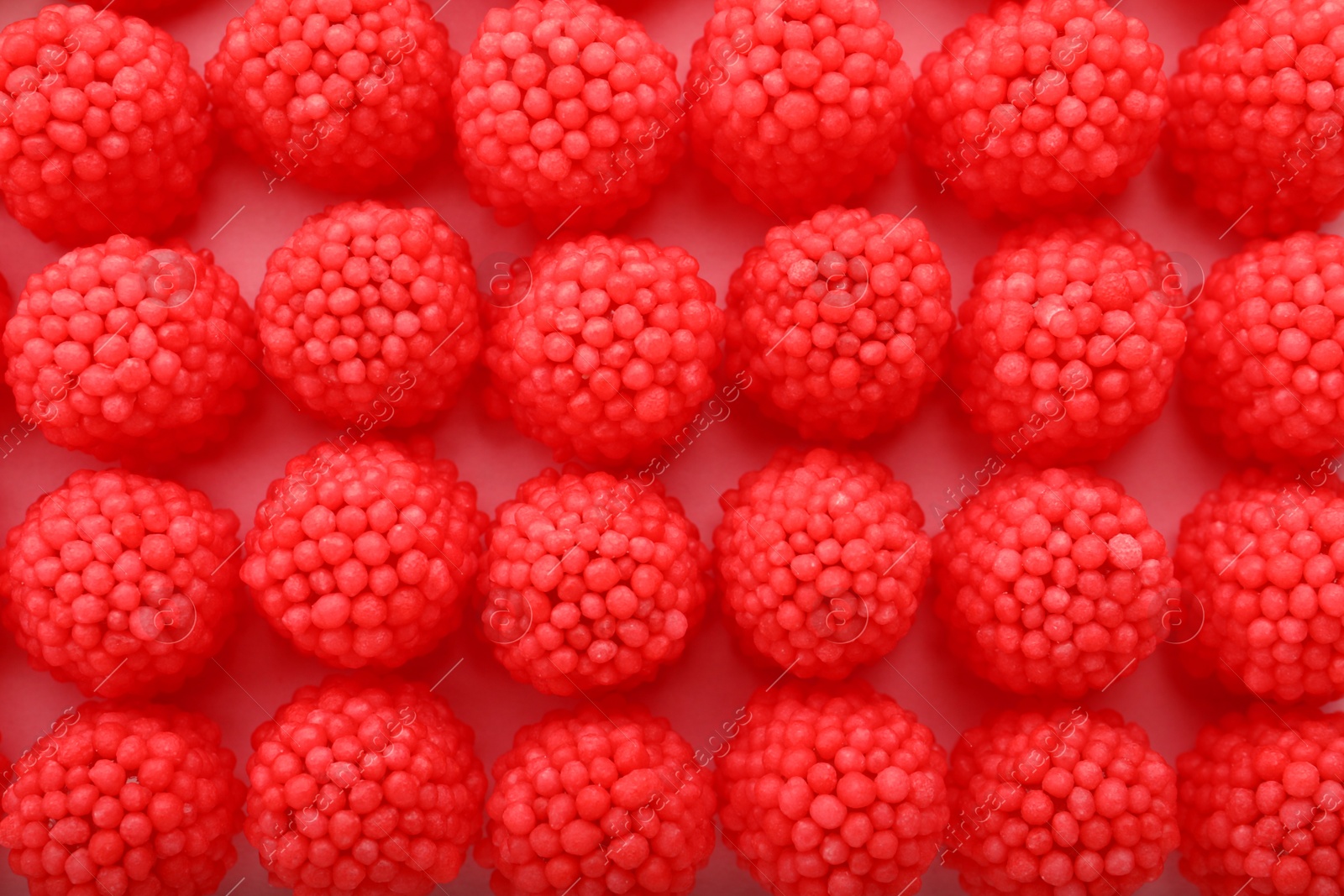 Photo of Delicious gummy raspberry candies on pink background, flat lay