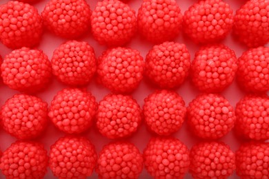 Delicious gummy raspberry candies on pink background, flat lay