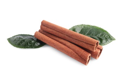 Aromatic cinnamon sticks and green leaves isolated on white