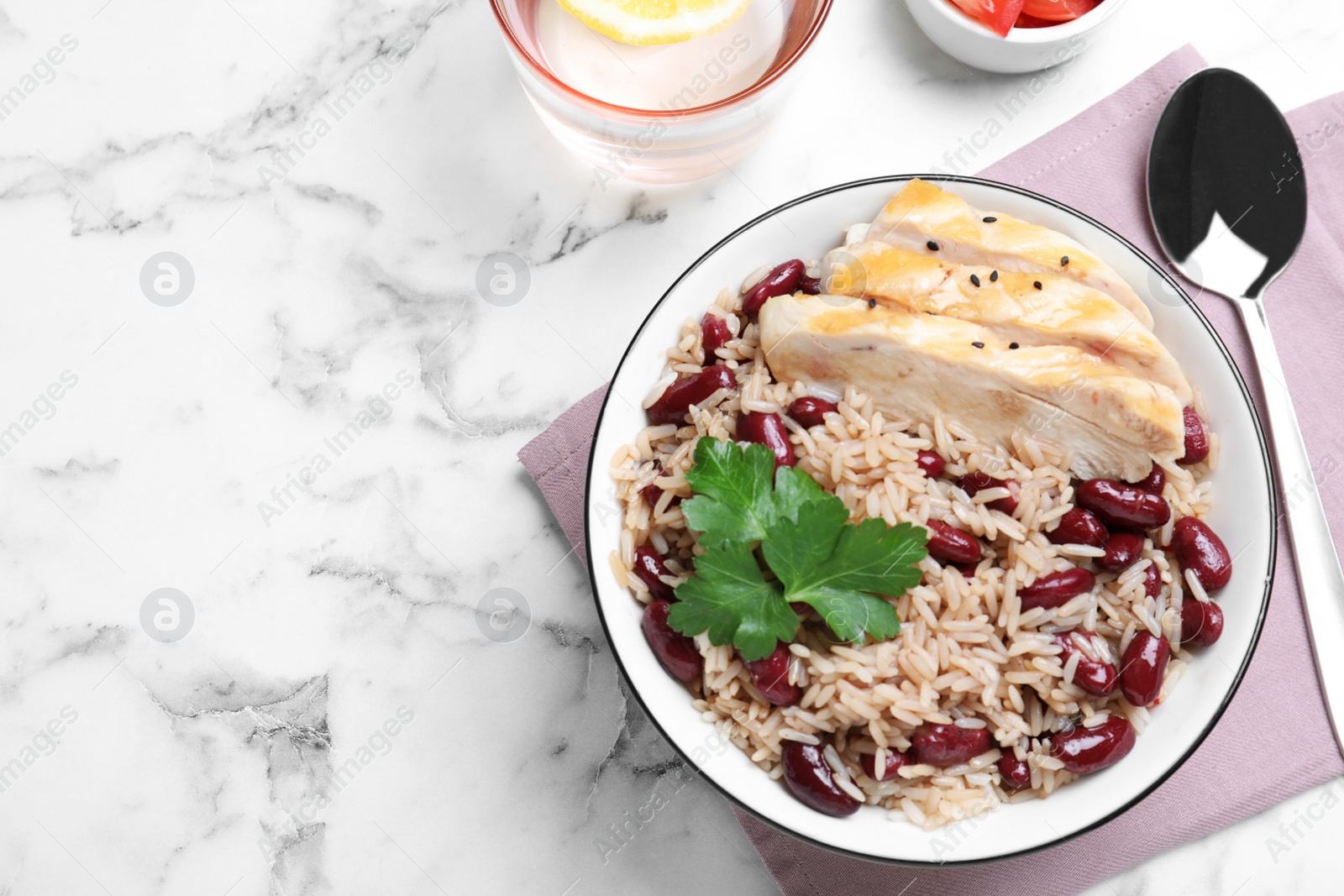 Photo of Delicious rice with beans and meat served on white marble table, flat lay. Space for text